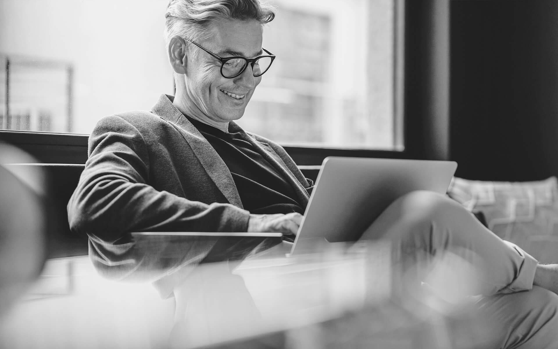 Senior-Berater arbeitet konzentriert an seinem Laptop, während er eine Strategie zur Verbesserung der Geschäftsprozesse entwickelt.